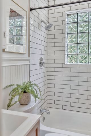 a bathroom with a granite countertop sink and a bathtub