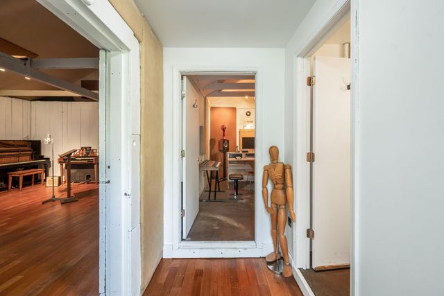 a view of a hallway with wooden floor windows and a livingroom
