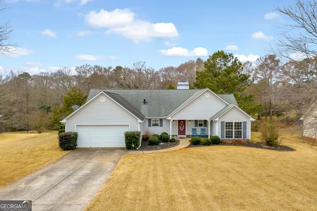 a front view of a house with a yard and trees