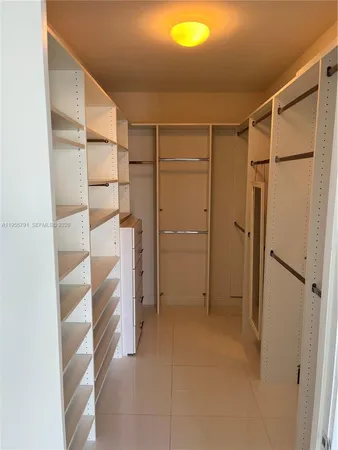 a view of walk in closet with empty racks