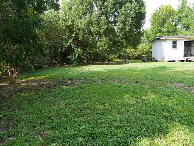 a view of backyard of house with green space