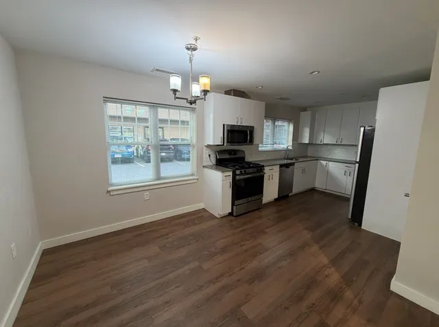 a view of kitchen with sink microwave refrigerator and cabinets