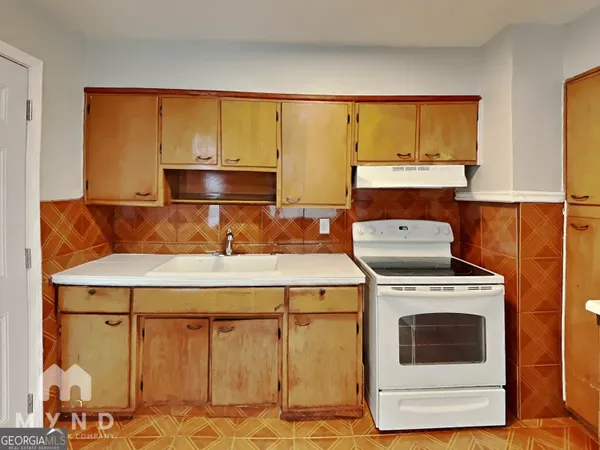 a stove top oven sitting inside of a kitchen