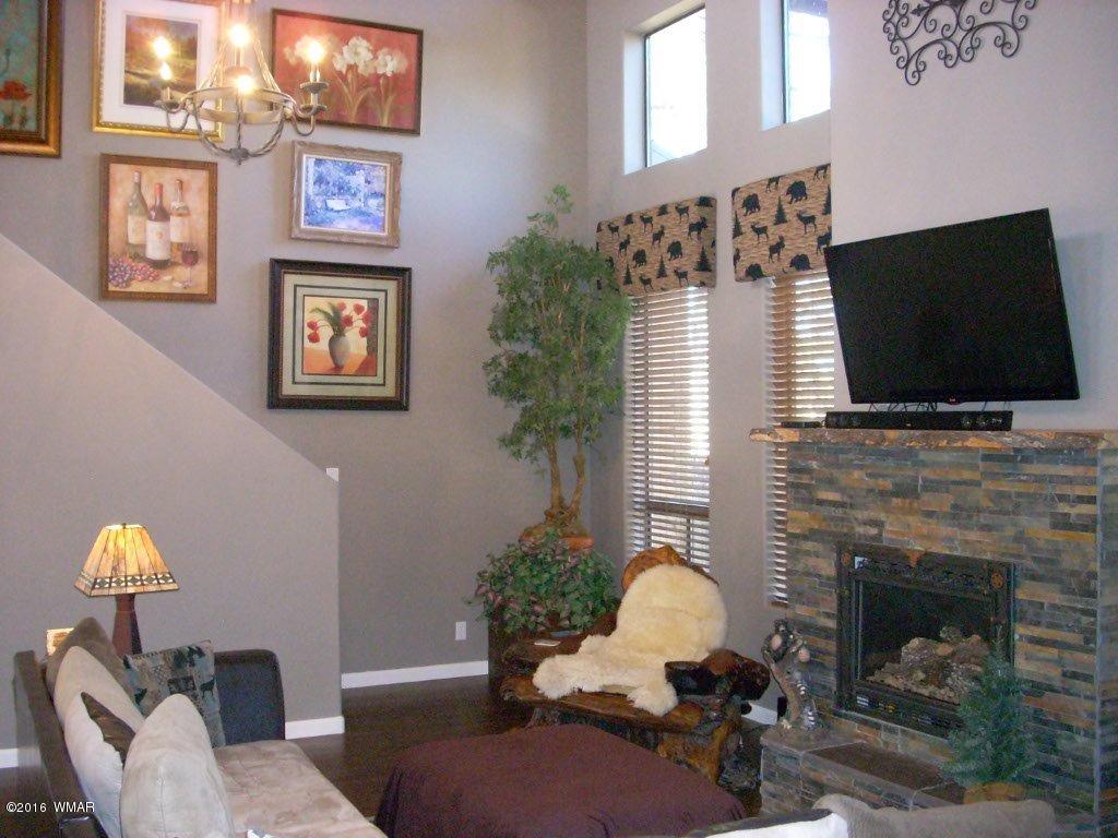 2975 East Lookout Lane Overgaard, AZ 85933 - Photo 11 of 34 a living room with furniture and a fireplace