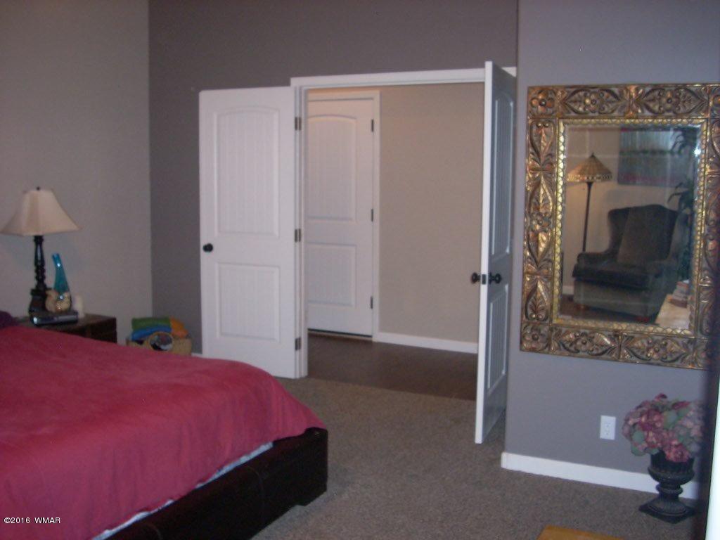 2975 East Lookout Lane Overgaard, AZ 85933 - Photo 13 of 34 a bedroom with a bed and a mirror