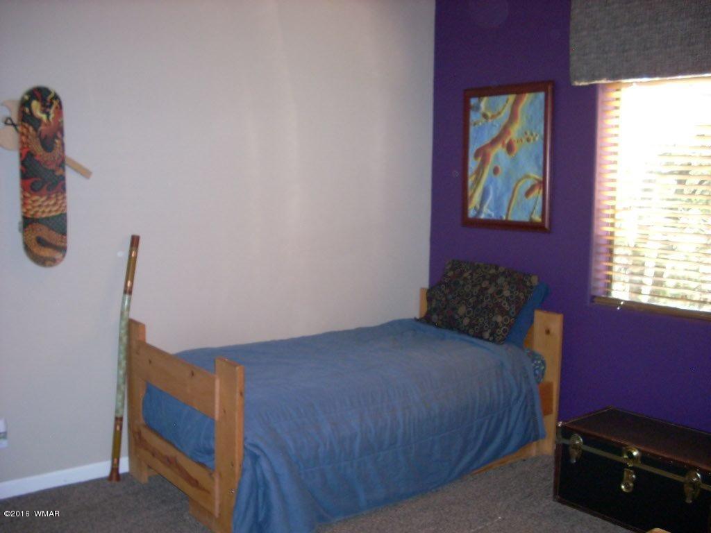 2975 East Lookout Lane Overgaard, AZ 85933 - Photo 16 of 34 a bedroom with a bed and a window