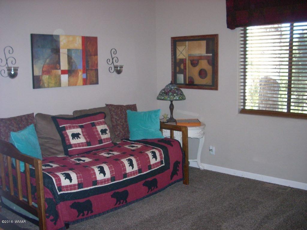 2975 East Lookout Lane Overgaard, AZ 85933 - Photo 17 of 34 a bedroom with a bed and painting on the wall