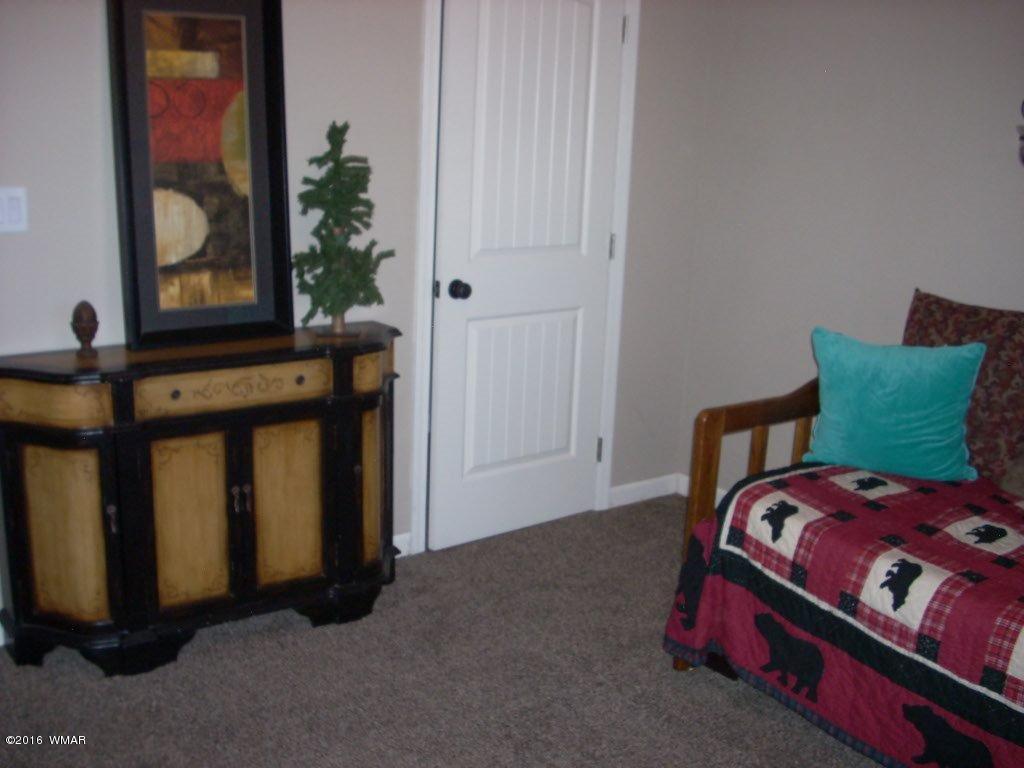 2975 East Lookout Lane Overgaard, AZ 85933 - Photo 18 of 34 a bed sitting in a bedroom next to a window