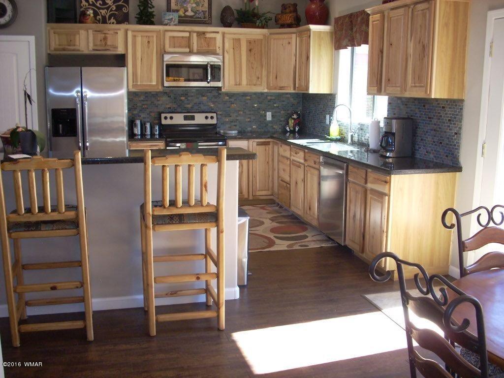 2975 East Lookout Lane Overgaard, AZ 85933 - Photo 21 of 34 a kitchen with stainless steel appliances granite countertop a stove a sink and a microwave