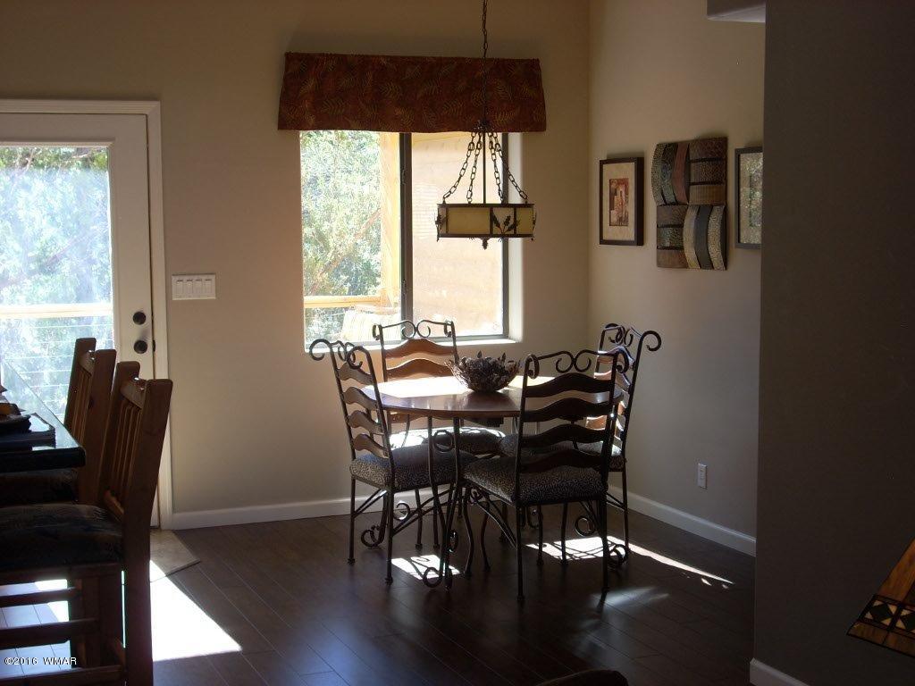 2975 East Lookout Lane Overgaard, AZ 85933 - Photo 31 of 34 a view of a dining room with furniture window and wooden floor