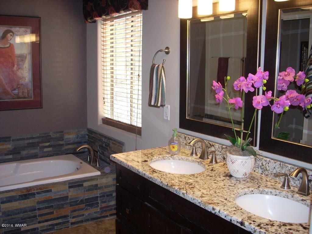 2975 East Lookout Lane Overgaard, AZ 85933 - Photo 34 of 34 a bathroom with a granite countertop sink a large mirror and a shower