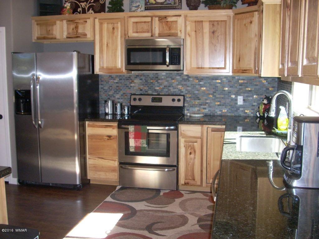 2975 East Lookout Lane Overgaard, AZ 85933 - Photo 6 of 34 a kitchen with granite countertop a refrigerator and a stove