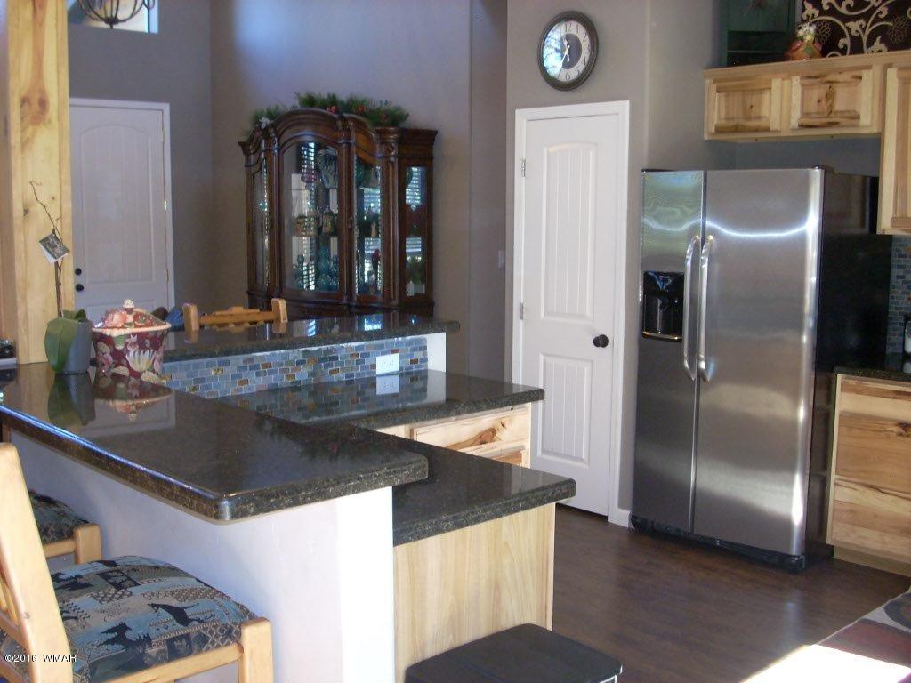 2975 East Lookout Lane Overgaard, AZ 85933 - Photo 7 of 34 a kitchen with granite countertop a refrigerator a stove and a sink