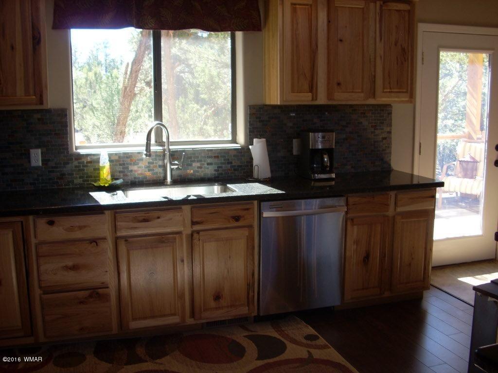 2975 East Lookout Lane Overgaard, AZ 85933 - Photo 8 of 34 a kitchen with granite countertop wooden cabinets a sink and a window