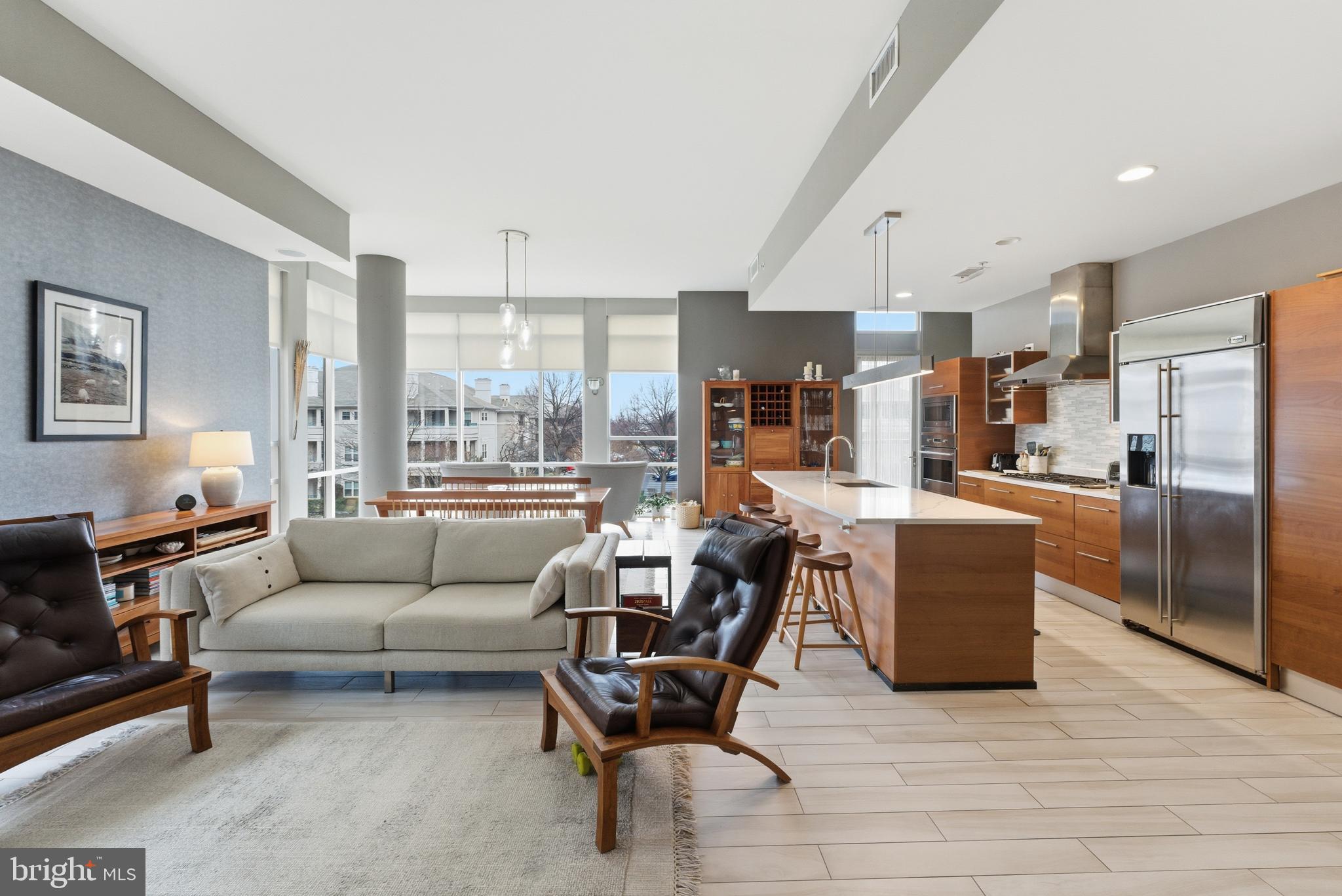 12025 New Dominion Parkway, Unit 103 Reston, VA 20190 - Photo 13 of 47 a living room with furniture and a dining table with kitchen view
