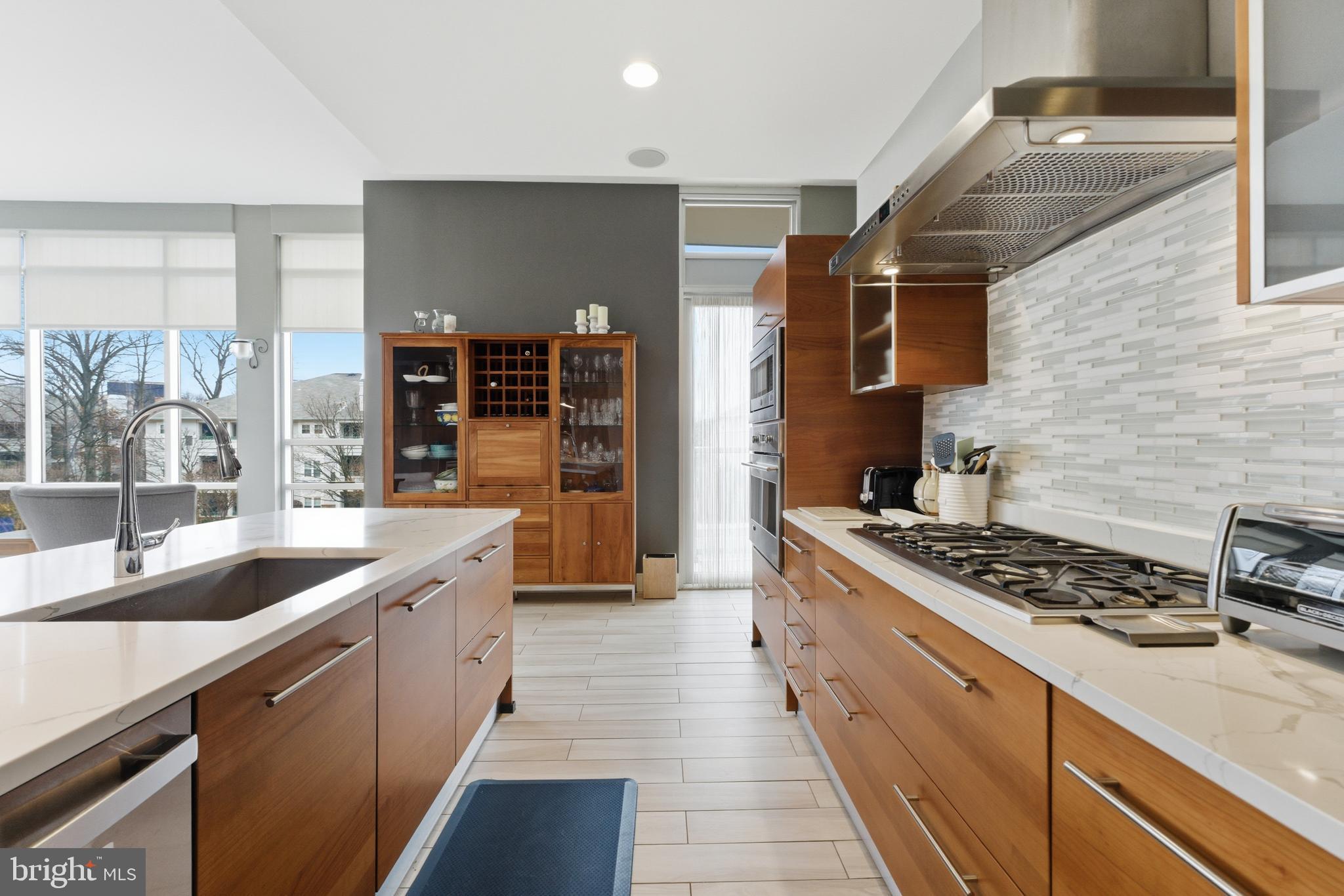 12025 New Dominion Parkway, Unit 103 Reston, VA 20190 - Photo 20 of 47 a kitchen with stainless steel appliances granite countertop a sink stove and cabinets