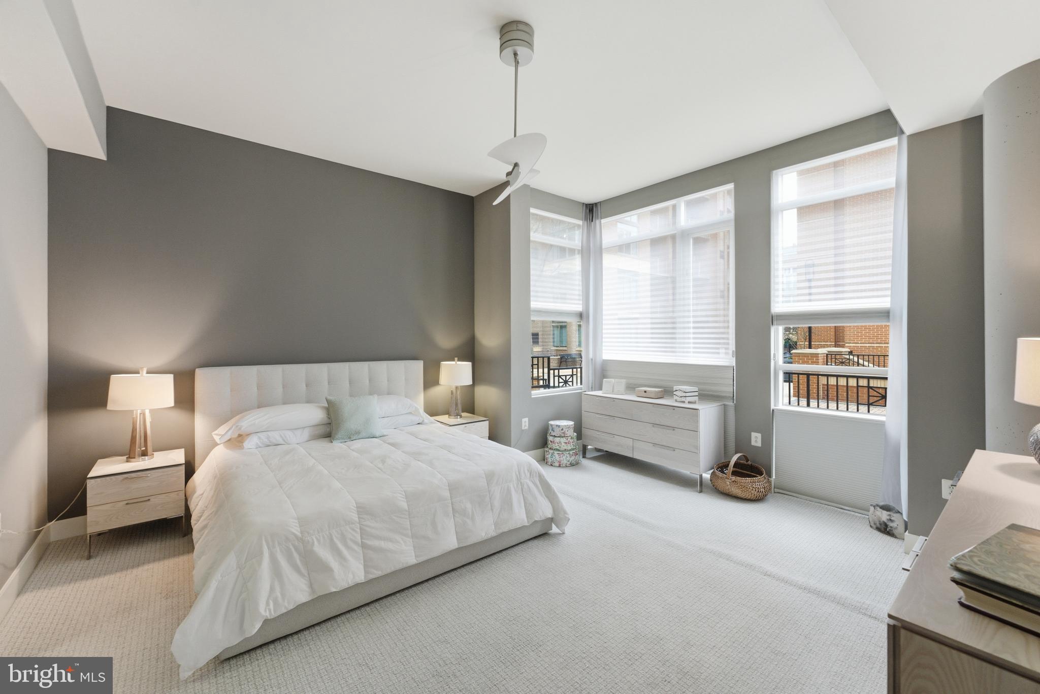 12025 New Dominion Parkway, Unit 103 Reston, VA 20190 - Photo 23 of 47 a spacious bedroom with a bed a couch and large window