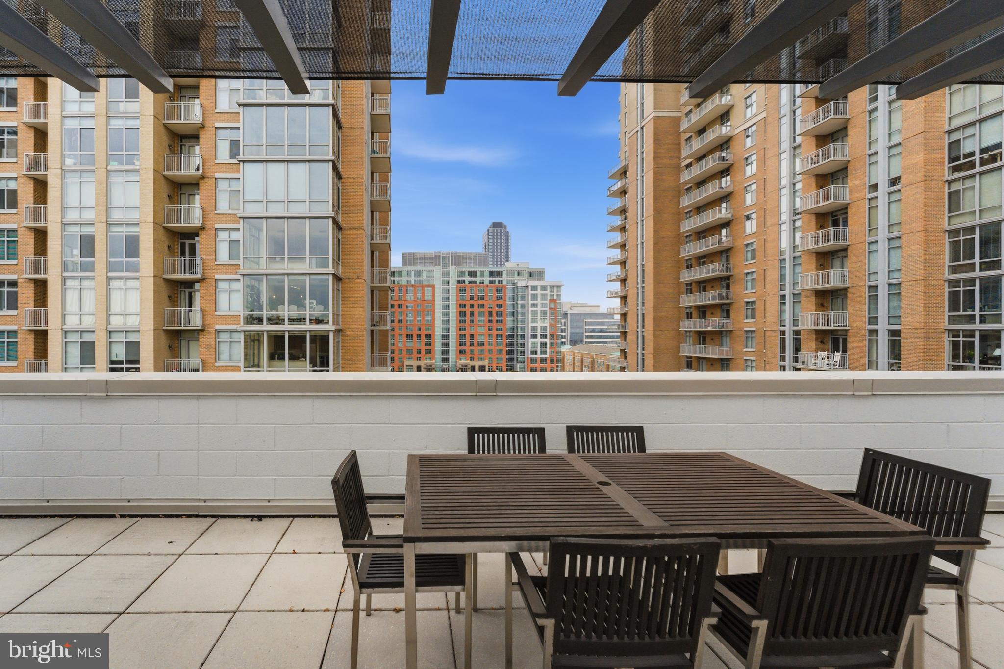12025 New Dominion Parkway, Unit 103 Reston, VA 20190 - Photo 39 of 47 a roof deck with table and chairs