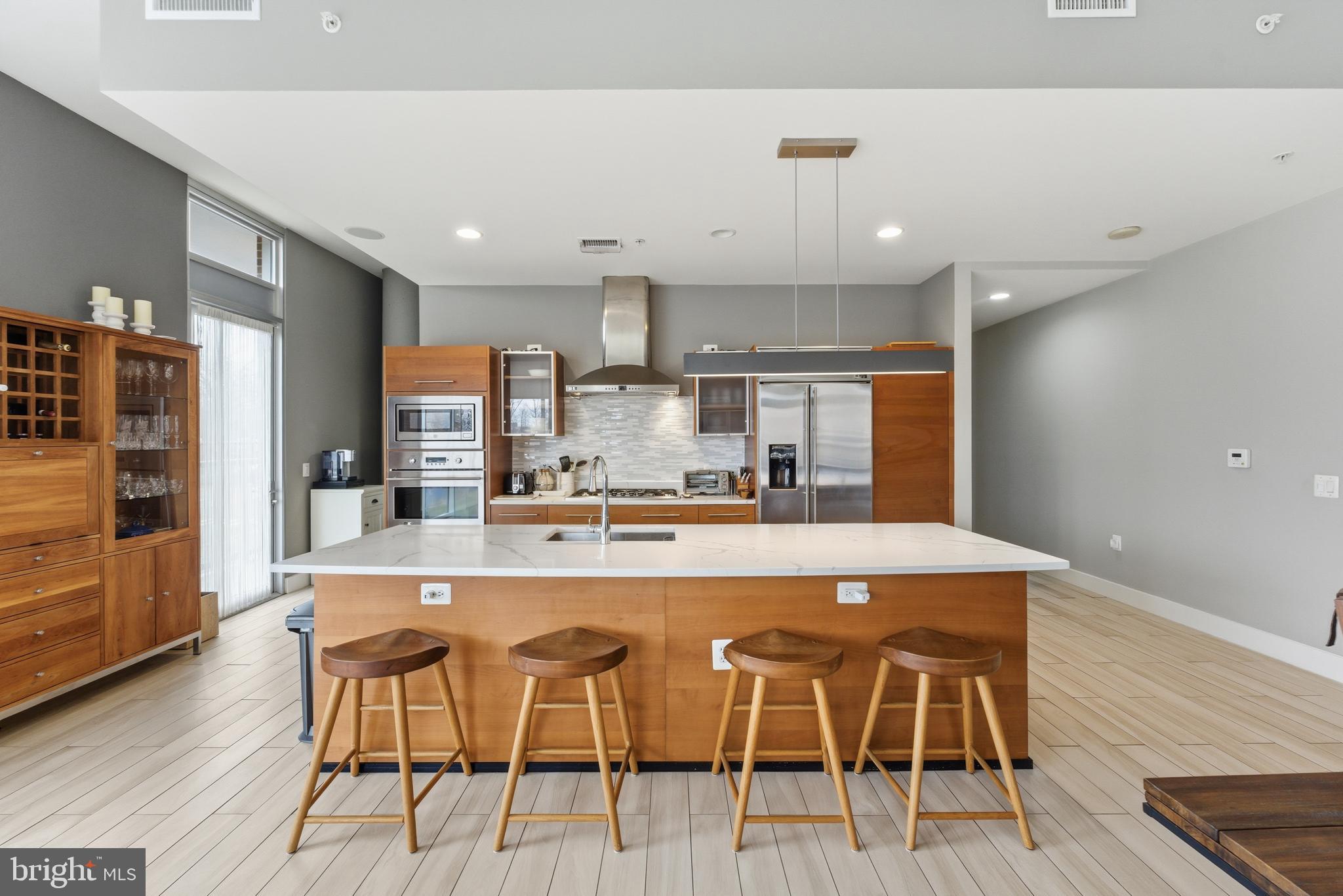 12025 New Dominion Parkway, Unit 103 Reston, VA 20190 - Photo 6 of 47 a large kitchen with a table and chairs