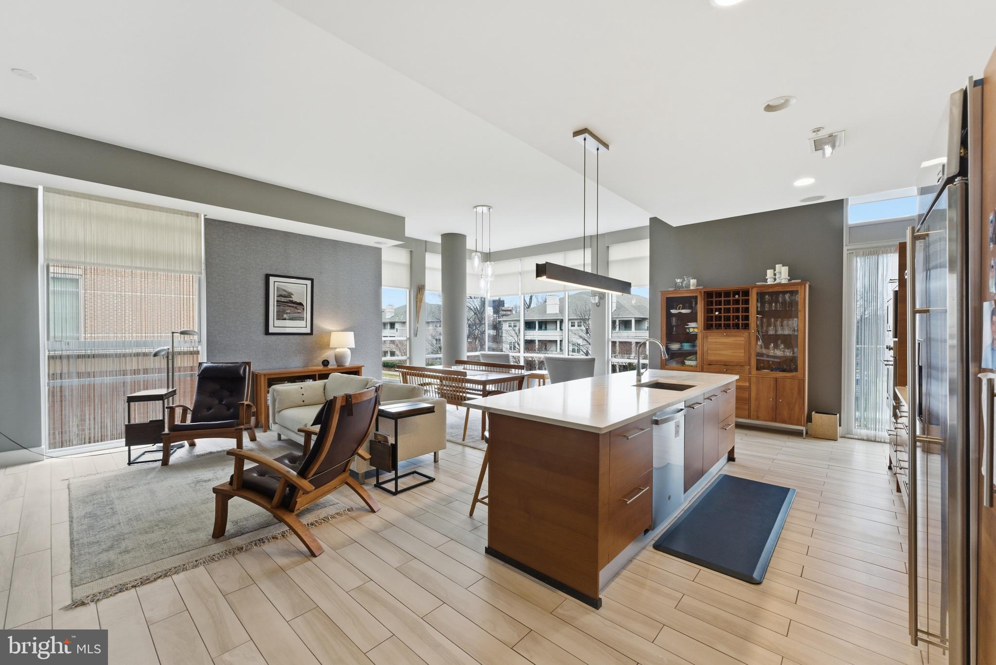 12025 New Dominion Parkway, Unit 103 Reston, VA 20190 - Photo 8 of 47 a living room with stainless steel appliances granite countertop furniture wooden floor and a view of kitchen