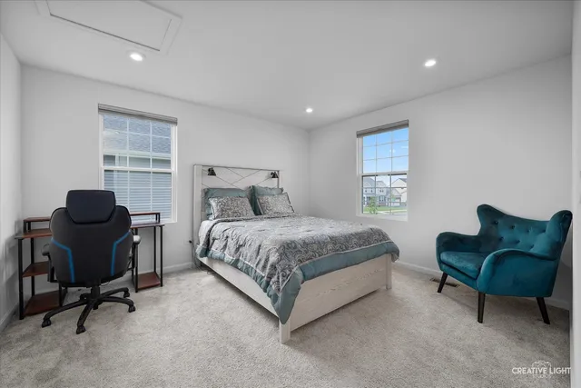 a bedroom with a bed chair and a window