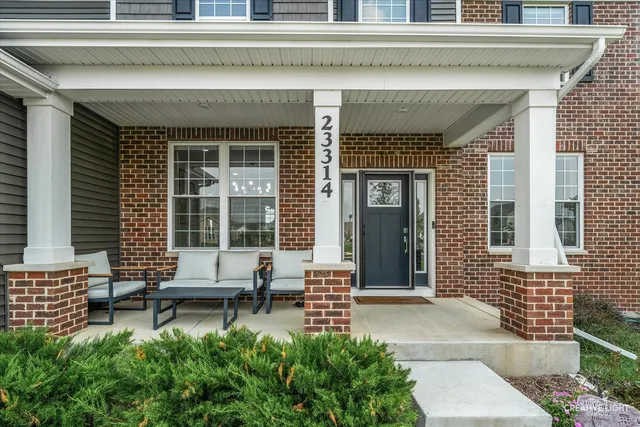 a front view of a house with a large window and sitting area