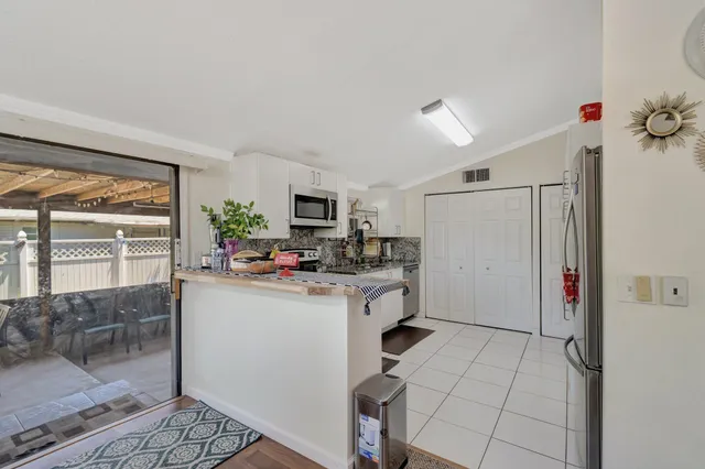 a kitchen with a refrigerator and a stove top oven