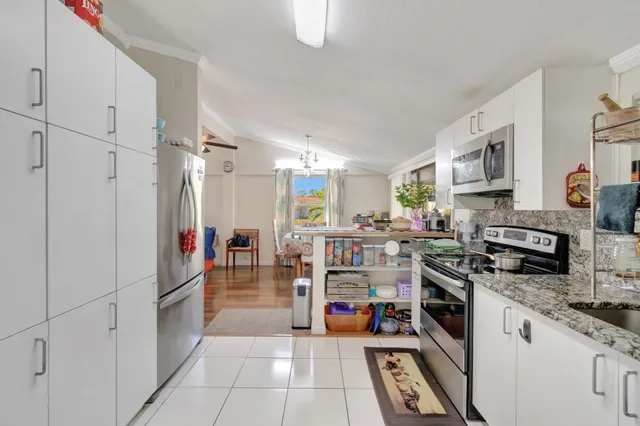 a kitchen with stainless steel appliances granite countertop a stove top oven a sink dishwasher and cabinets with wooden floor