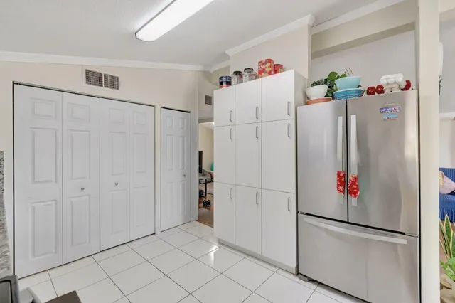a white refrigerator freezer sitting in a kitchen with refrigerator and white cabinets