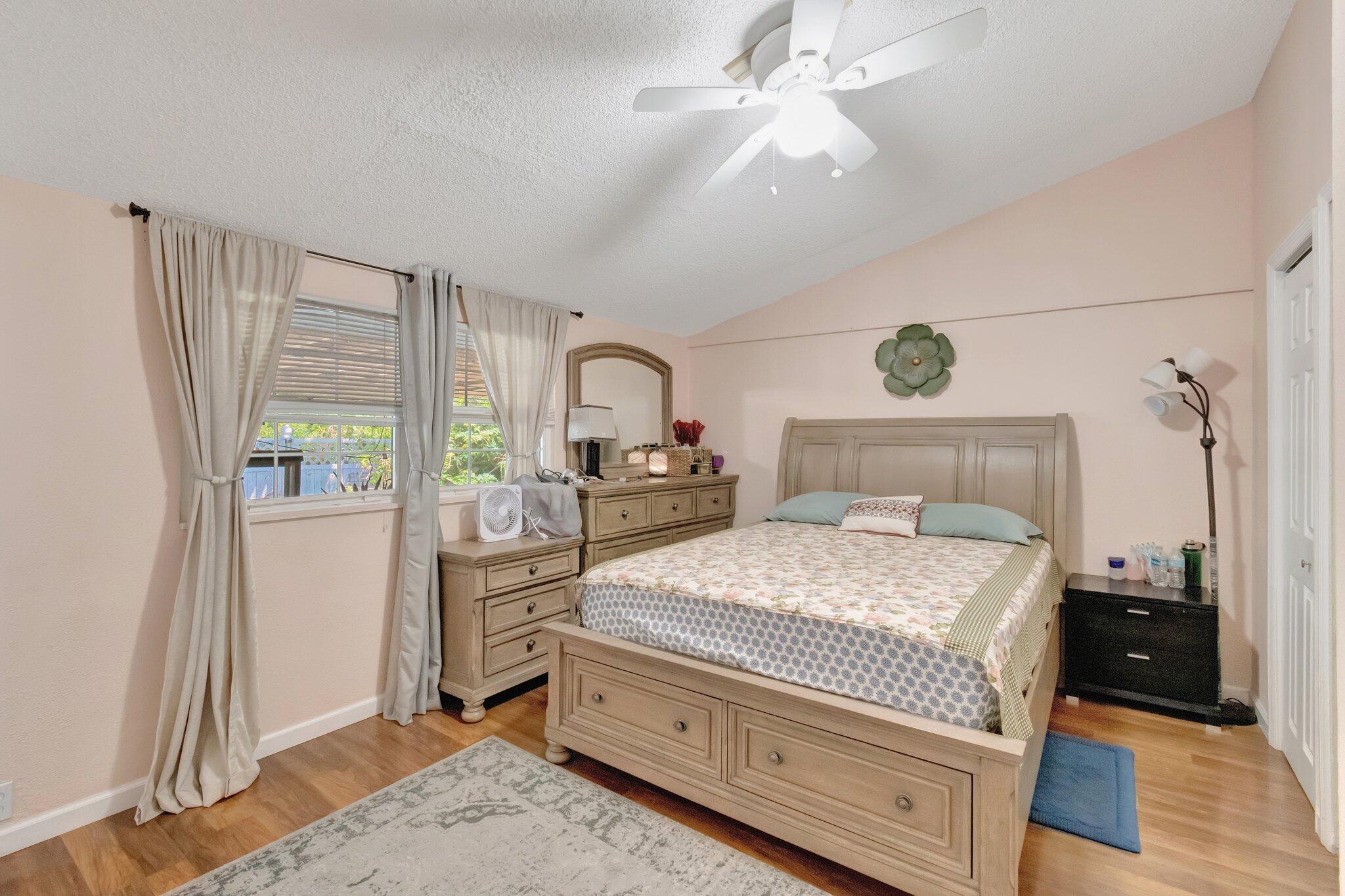 3935 Chickasha Road Atlantis, FL 33462 - Photo 19 of 44 a bedroom with a bed and a chandelier