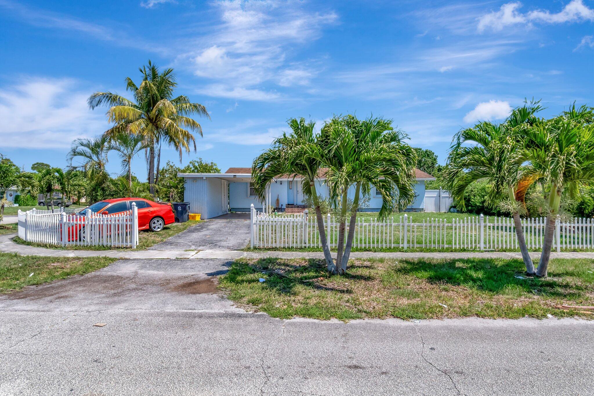 3935 Chickasha Road Atlantis, FL 33462 - Photo 2 of 44 a small garden in the back yard