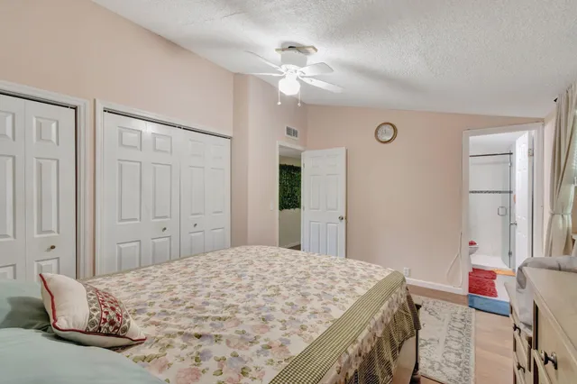 a bedroom with a bed dresser and a chandelier