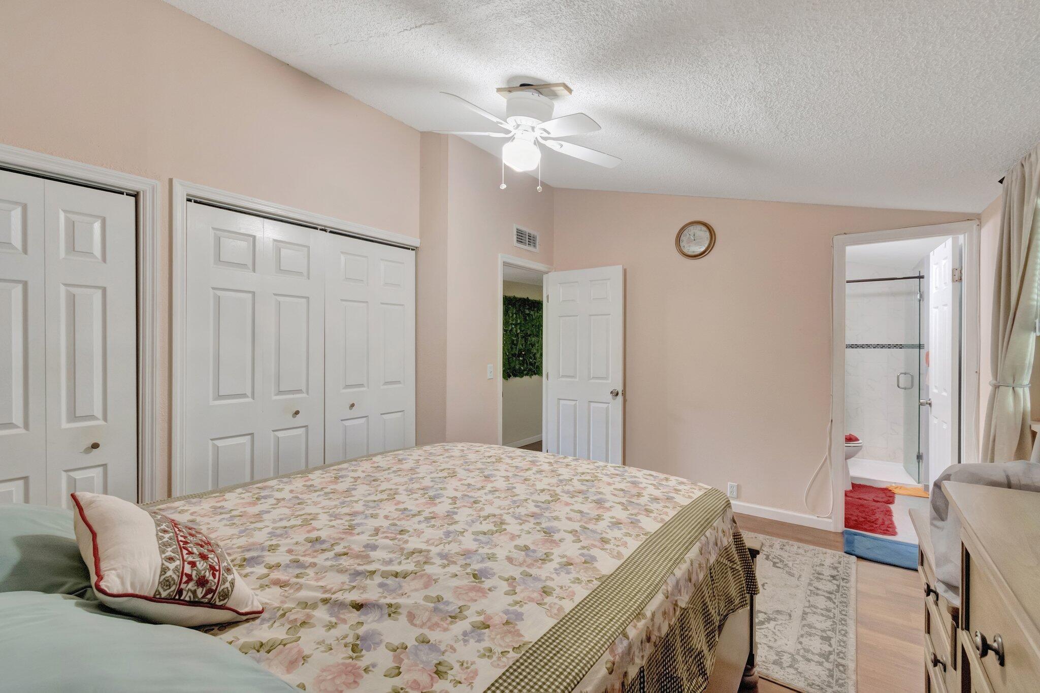 3935 Chickasha Road Atlantis, FL 33462 - Photo 21 of 44 a bedroom with a bed dresser and a chandelier