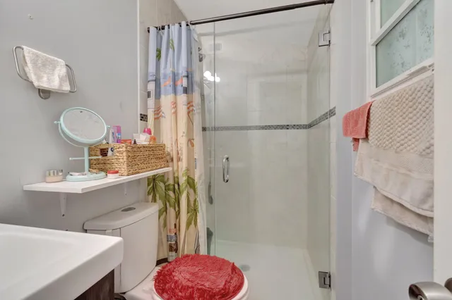 a bathroom with a sink toilet a mirror and shower