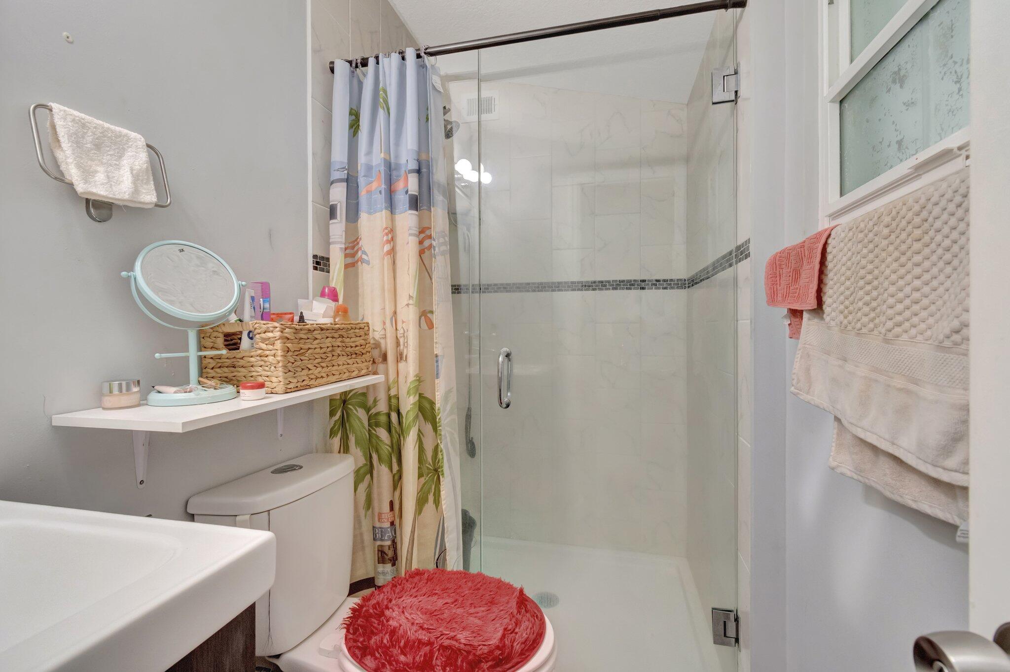 3935 Chickasha Road Atlantis, FL 33462 - Photo 23 of 44 a bathroom with a sink toilet a mirror and shower