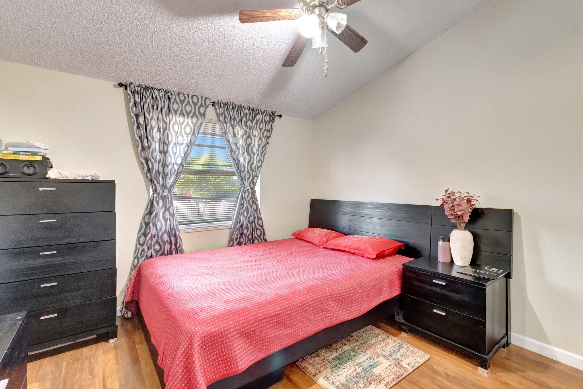 3935 Chickasha Road Atlantis, FL 33462 - Photo 26 of 44 a bedroom with a bed and a chandelier