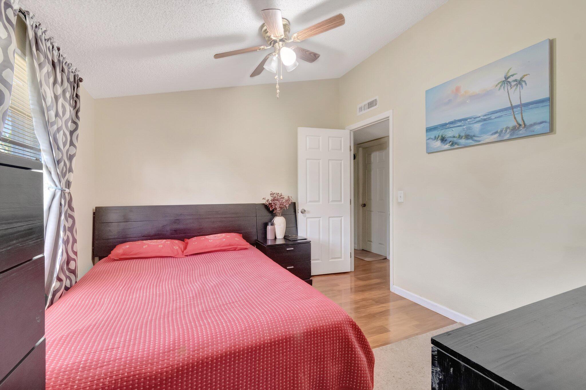 3935 Chickasha Road Atlantis, FL 33462 - Photo 27 of 44 a bedroom with a bed and a chandelier