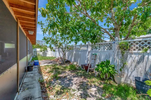 a view of house with backyard and sitting area