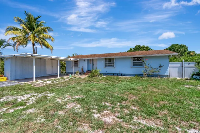 a view of a house with a yard and tree