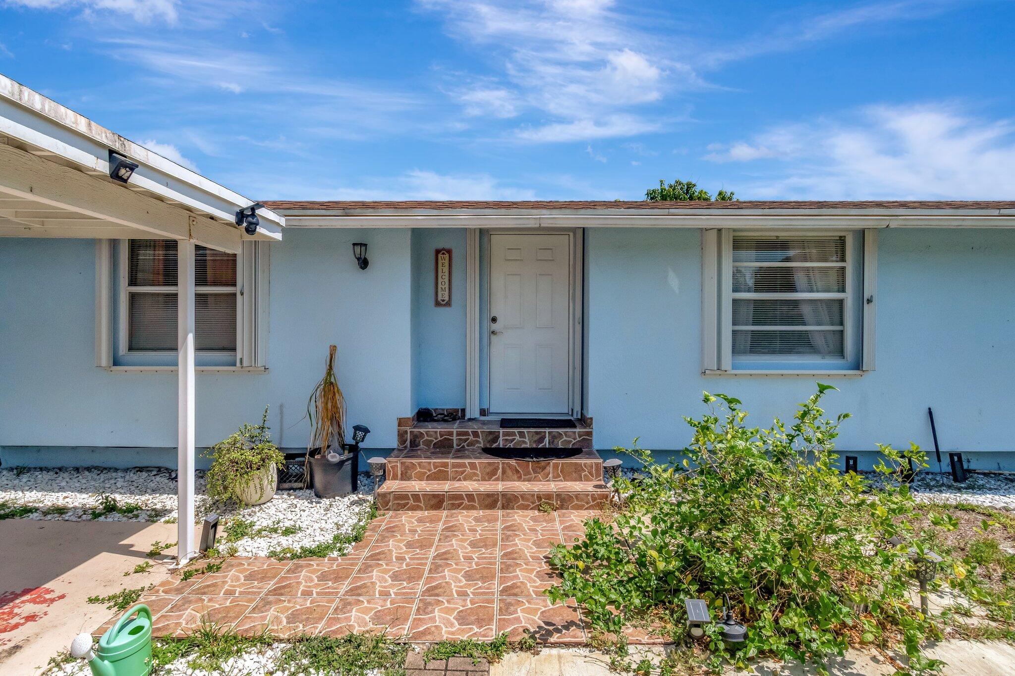 3935 Chickasha Road Atlantis, FL 33462 - Photo 6 of 44 a front view of a house with a yard