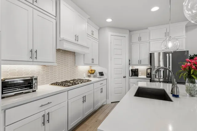 a kitchen with white cabinets and appliances