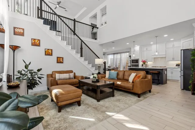 a living room with furniture kitchen view and a potted plant