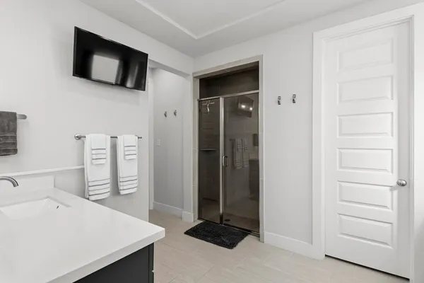 a bedroom with a bed a flat screen tv and a large window