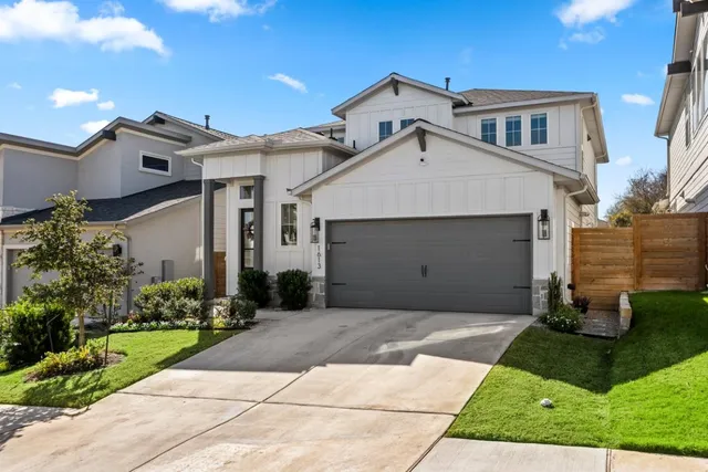 a front view of a house with a garden and plants