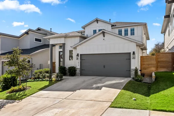 a front view of a house with a garden and plants