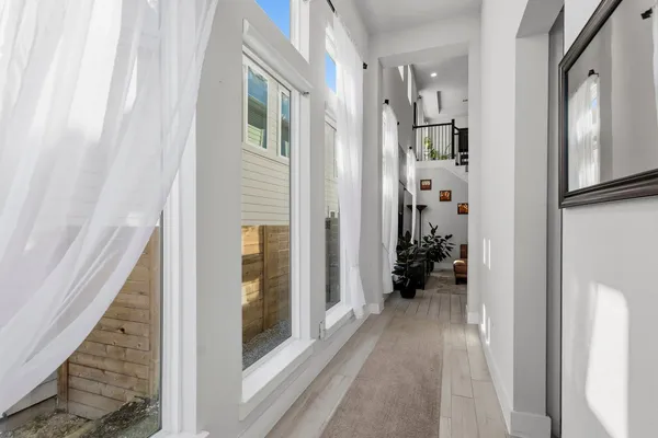 a view of a hallway with wooden floor and entryway