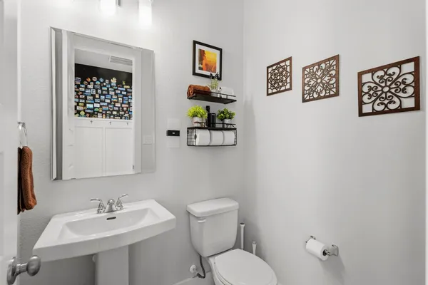 a bathroom with a toilet a sink and mirror