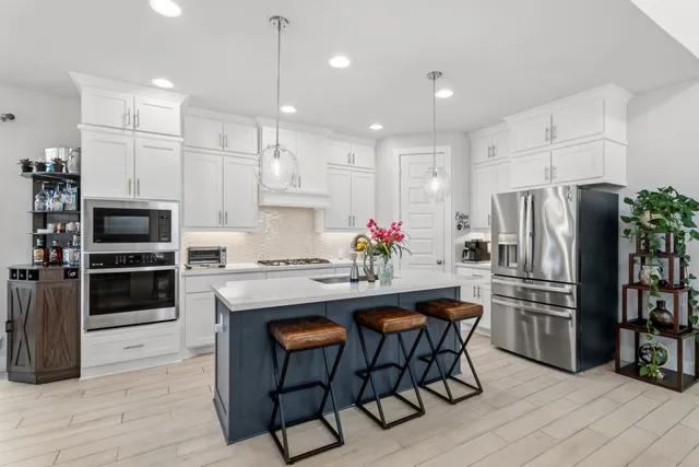 a kitchen with kitchen island a dining table and chairs
