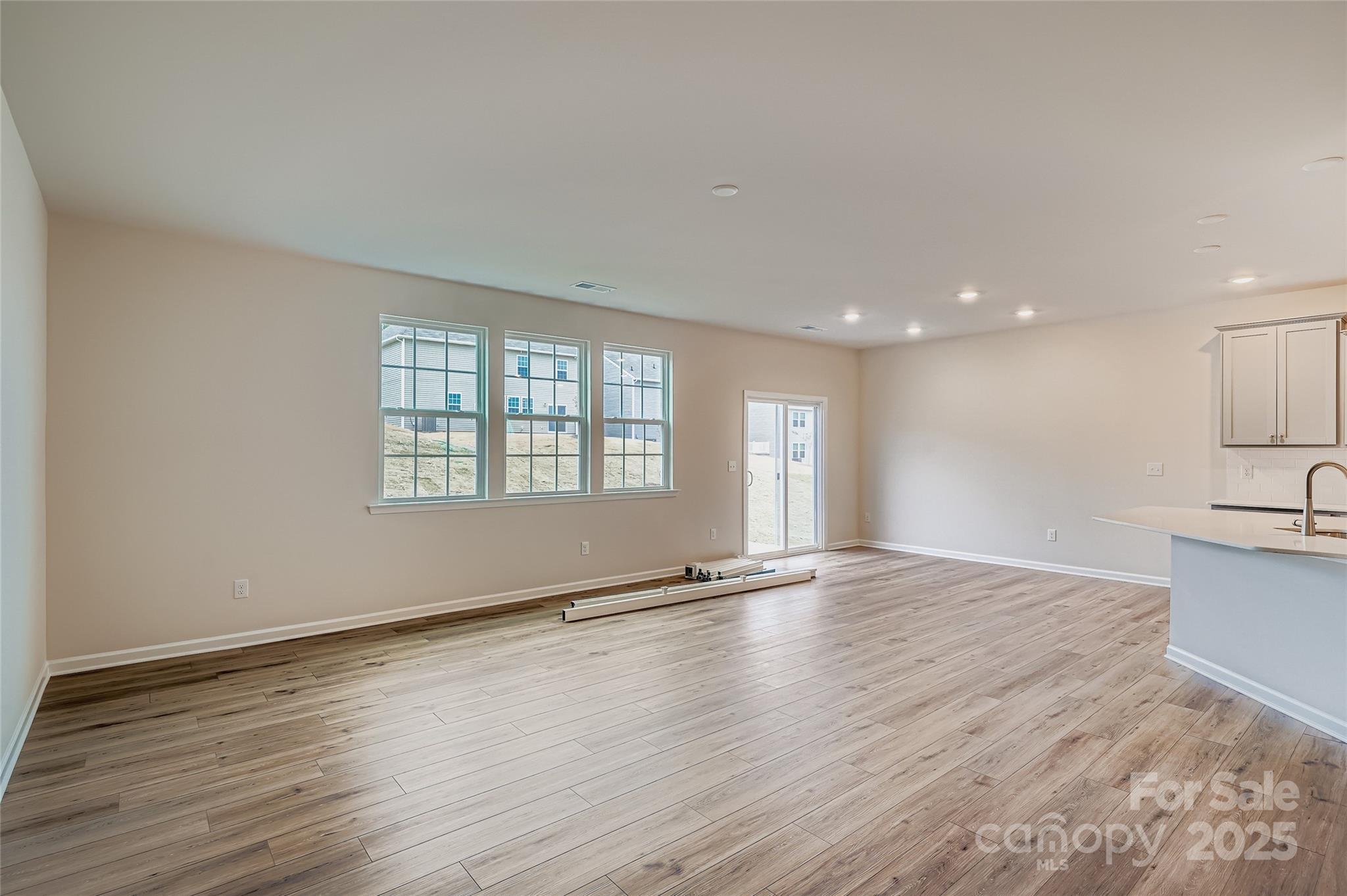4344 Shimmering Stone Way Maiden, NC 28650 - Photo 3 of 13 an empty room with wooden floor and windows