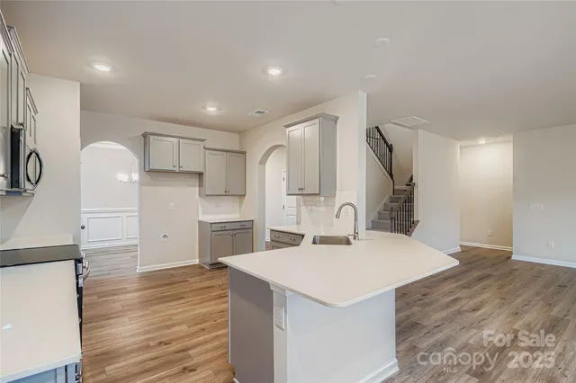 a kitchen with a sink cabinets stainless steel appliances and windows